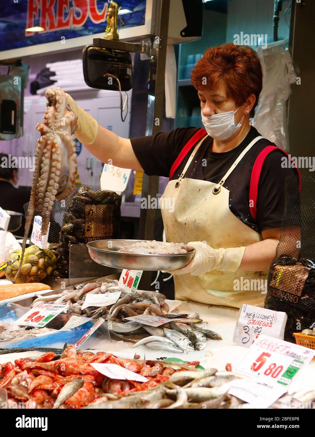 18 avril 2020, Espagne, Palma: Un vendeur de poisson sert un poulpe aux clients à son stand dans le marché traditionnel de la Plaza Olivar à Palma de Majorque. Photo: Clara Margais/dpa Banque D'Images