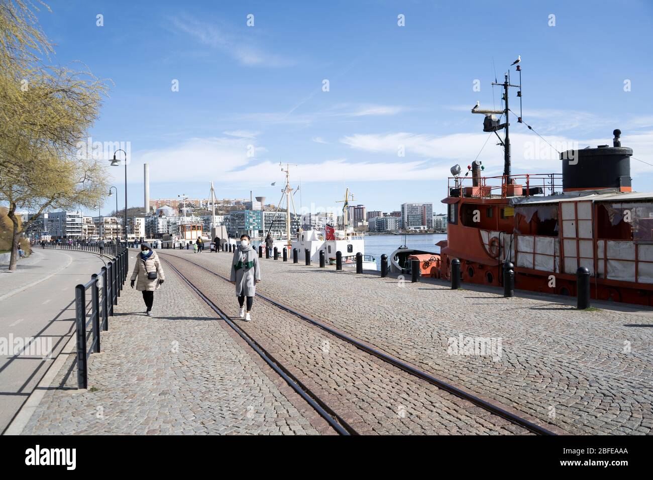 Stockholm, Suède - Coronavirus, urgence. Maman et fille marchent sur le sentier de la mer et portent un masque de sécurité pour le virus corona. Banque D'Images