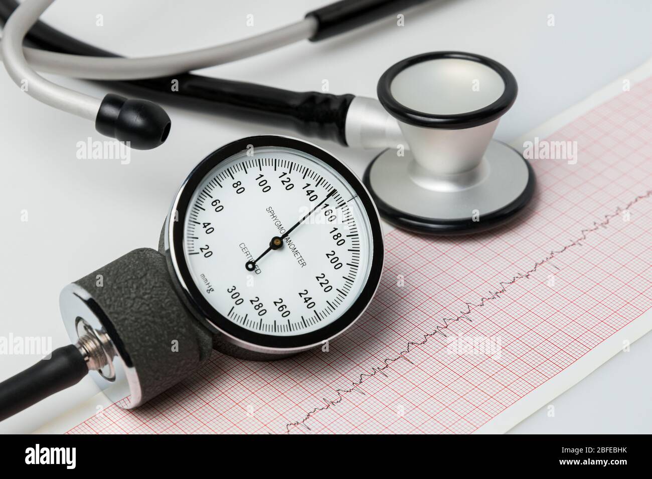 Gros plan de la jauge du brassard de pression artérielle, du stéthoscope et de la séquence de rythme cardiaque EKG ou ECG. Concept de santé cardiaque, d'hypertension et de régime alimentaire Banque D'Images