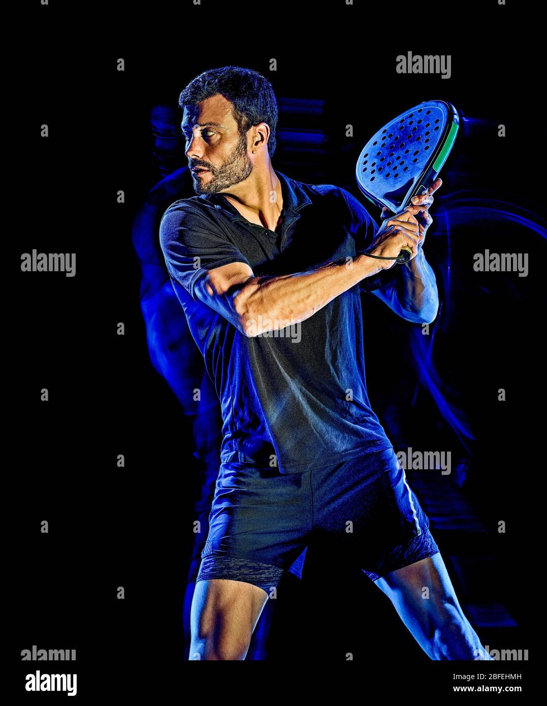 Un portrait du paddle tennis player man studio shot isolé sur fond noir avec le light painting effet flou Banque D'Images