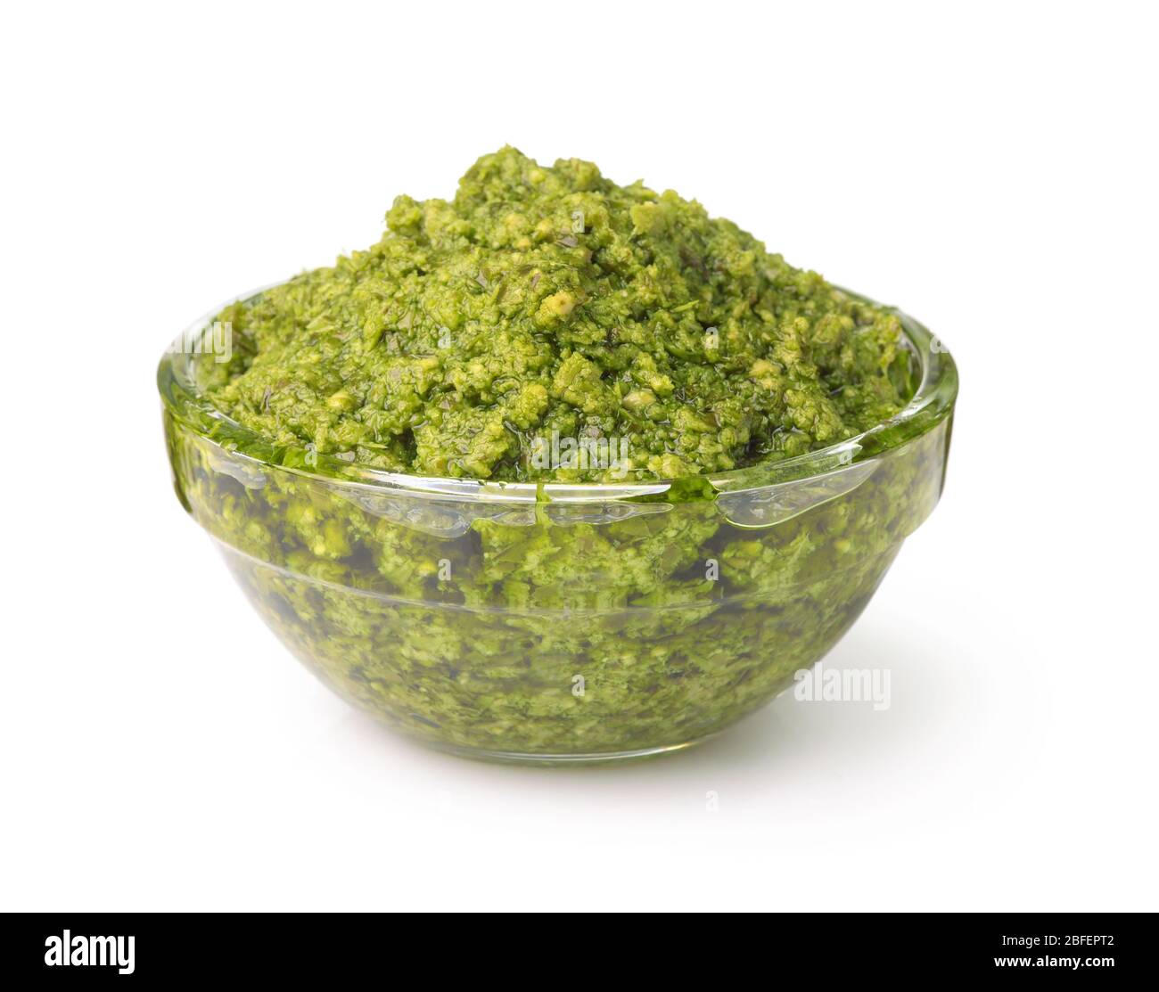 Bol en verre de sauce pesto fraîche isolé sur blanc Banque D'Images