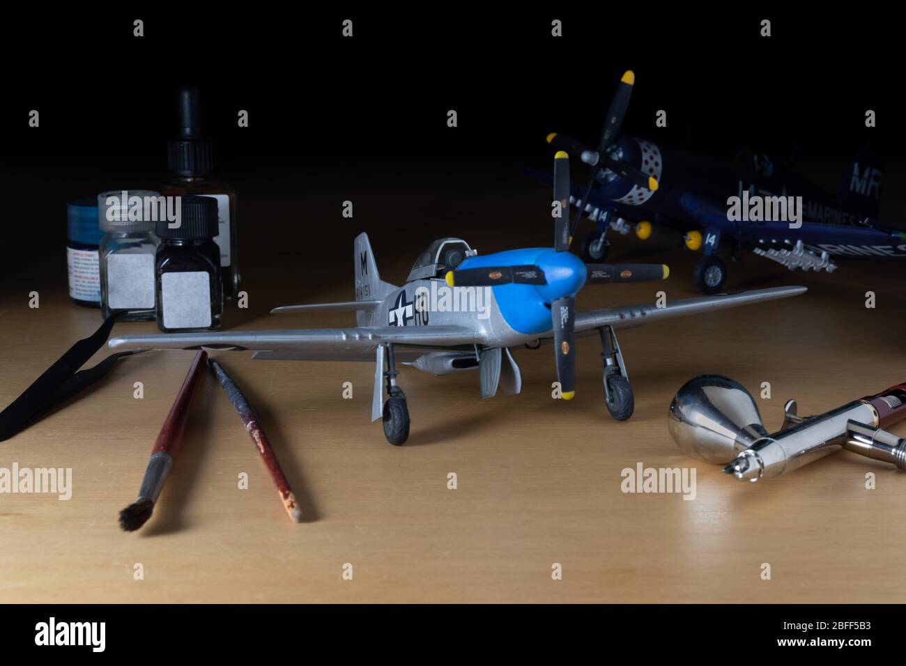 Figurines d'aéronefs et d'échelle représentation de kits de modélisation par passe-temps avec outils. Modèle P-51, brosses, peinture et aérographe. Banque D'Images