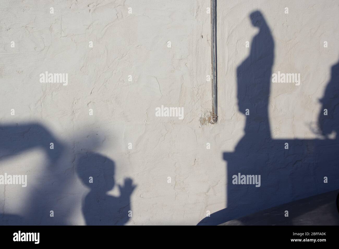 Ombre d'un enfant priant à la statue de la Madonna Banque D'Images