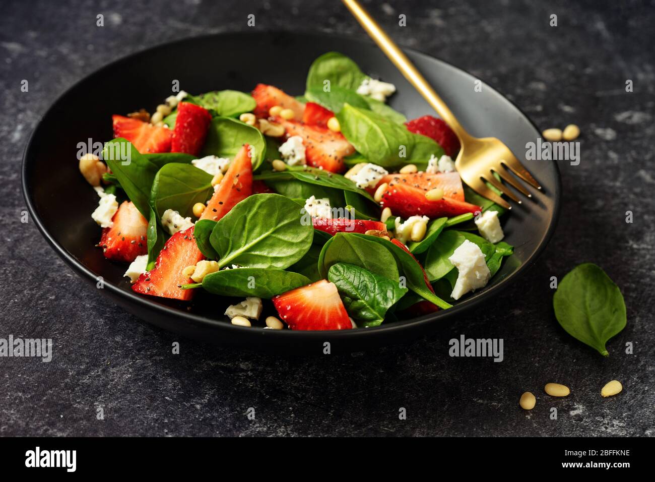 Gros plan de salade de fraises saine avec des épinards, des feta et des pignons Banque D'Images