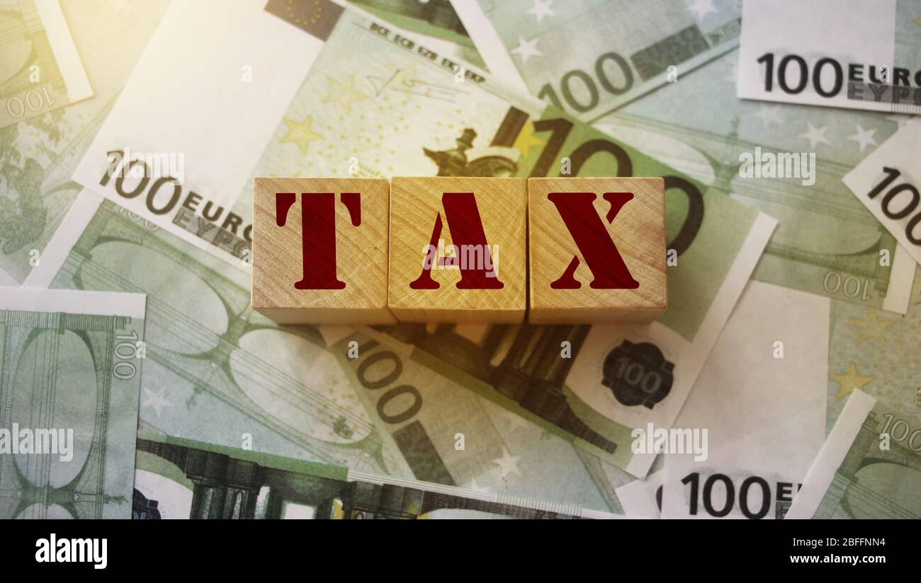 Blocs en bois avec taxe de mot sur 100 billets en euros. Concept comptable de financement des impôts Banque D'Images