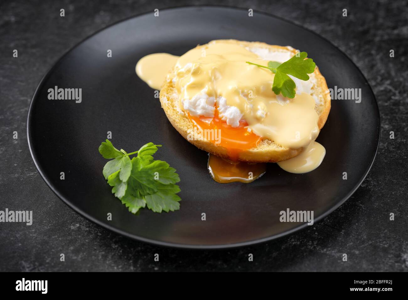 Gros plan d'une assiette noire avec un œuf poché Banque D'Images