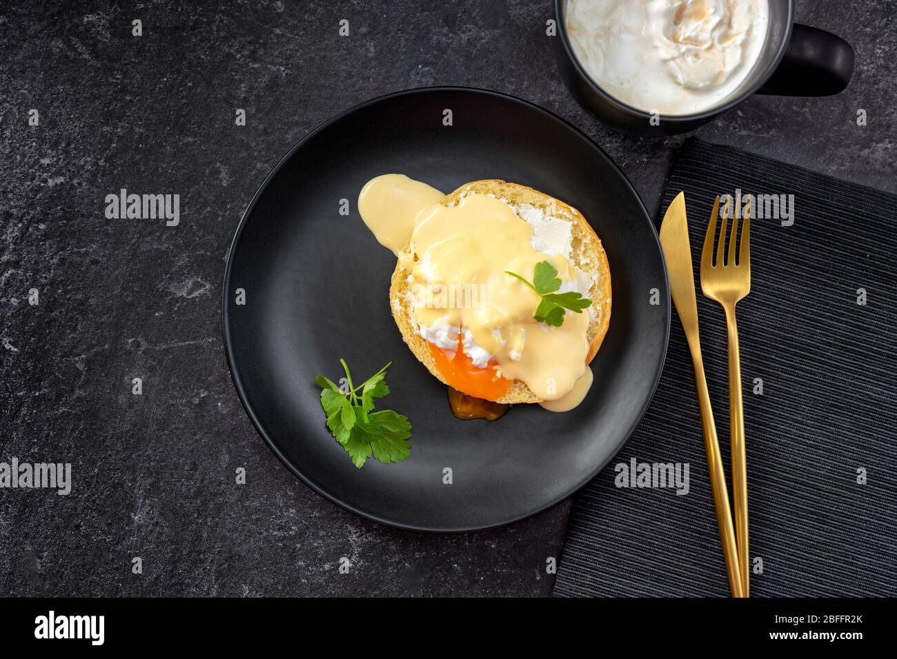 Vue de dessus de l'œuf poché dans une assiette noire et or en métal Banque D'Images