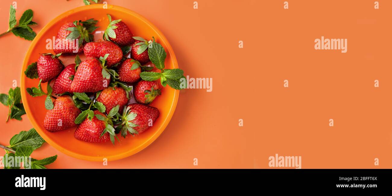 Vue de dessus d'une assiette avec fraisier frais sur tendance arrière-plan orange Banque D'Images