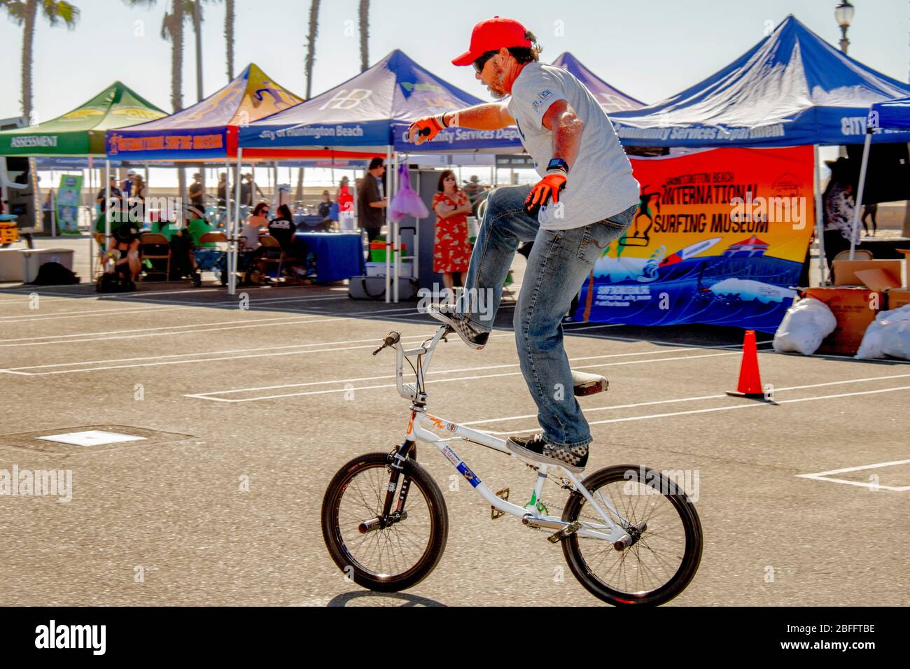 Un vélo d'équipe Freestyle BMX montre un équilibre prudent lors d'une démonstration d'aptitude dans un parking Huntington Beach, Californie. Banque D'Images