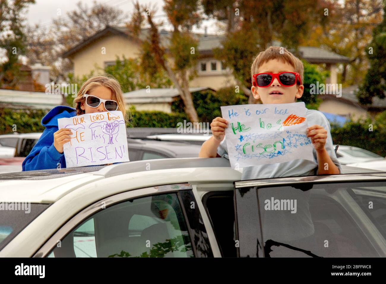 Les enfants qui travaillent à Pâques dans un parc de bureaux de Santa Ana, Californie, ont fait des expositions d'art maison disant « il est ressuscité ». Banque D'Images