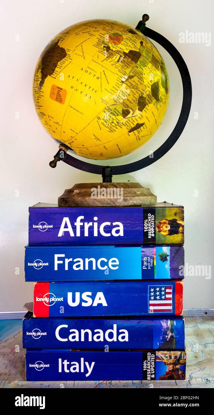 Pile de guides et d'articles de voyage et un globe Banque D'Images