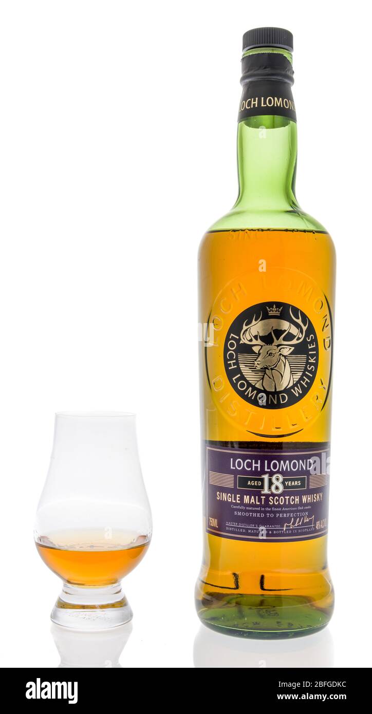 Winneconne, WI - 12 avril 2020: Une bouteille de whisky single malt Loch lomond de 18 ans avec un verre de Glencairn sur un fond isolé. Banque D'Images