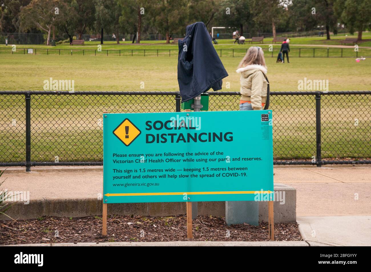 L'avis des autorités locales dans un parc de banlieue favorise les distanciation sociale pendant la pandémie COVID-19, Melbourne, Australie Banque D'Images