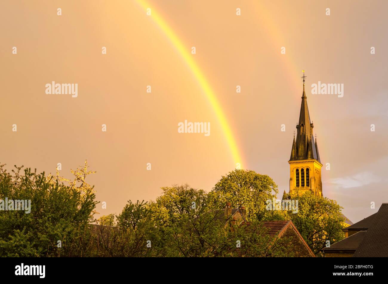 Rainbow au-dessus de l'église Saint-Mard avec le clocher frappé par la lumière du soleil Banque D'Images Rainbow au-dessus de l'église Saint-Mard avec le clocher frappé par la lumière du soleil Banque D'Images