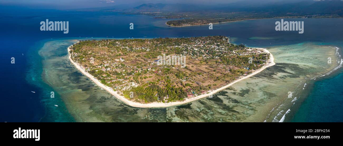 Vue panoramique aérienne d'une petite île tropicale entourée d'un récif de corail frangeant (Gili Air) Banque D'Images