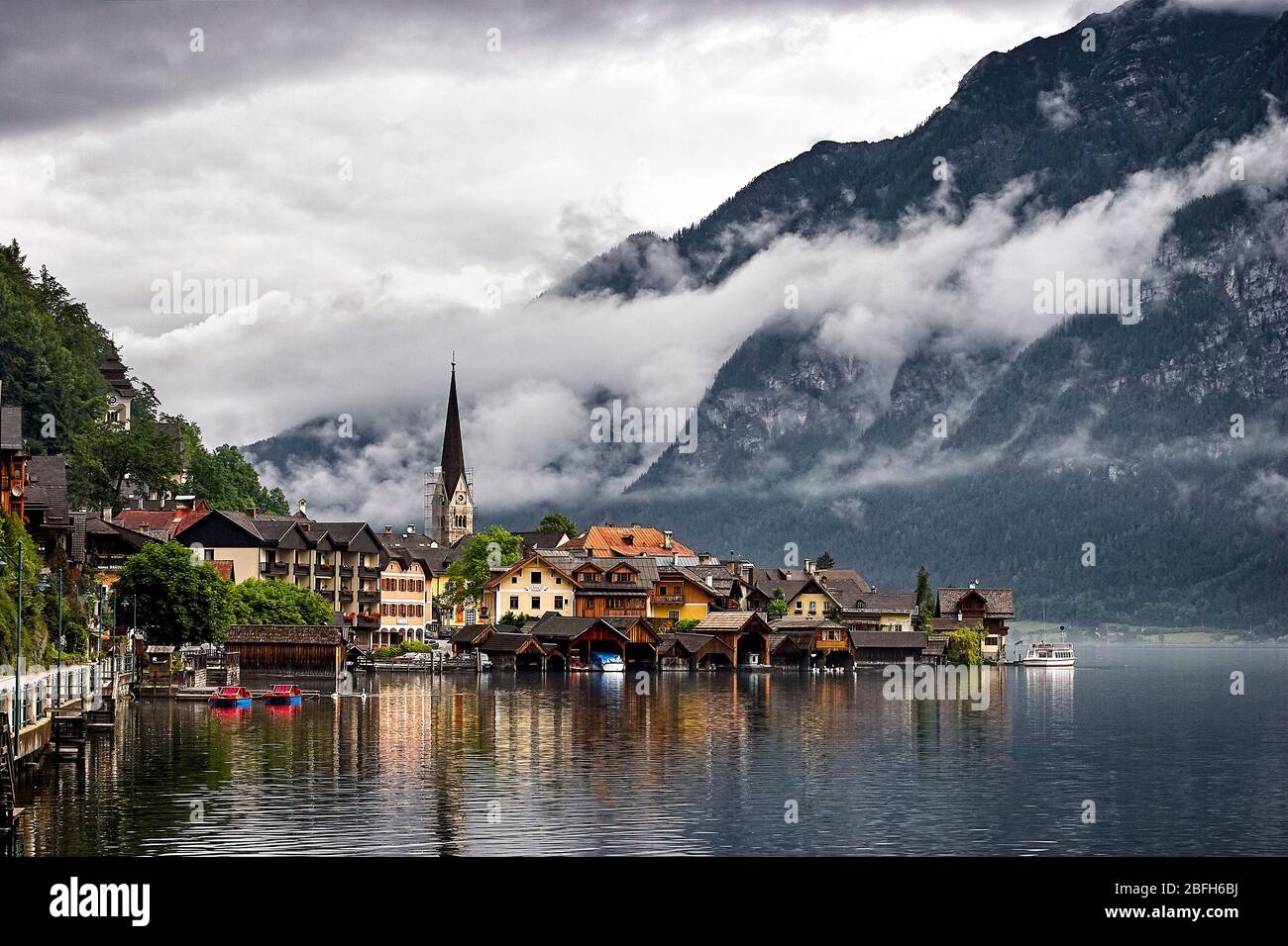 Nuages bas penchant sur le village de Hallstatt et les montagnes environnantes. Hallstatt, Salzkammergut, Autriche. Banque D'Images