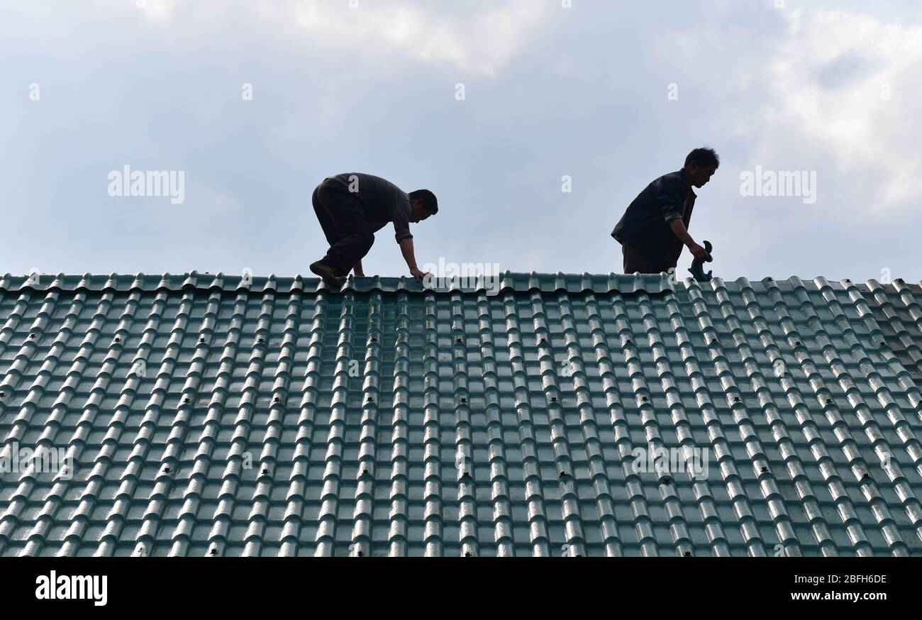 (200419) -- RONGSHUI, 19 avril 2020 (Xinhua) -- le père de Liang Mengxiang Liang Qinghua (L) maintient la maison au village de Dangjiu dans le canton de Gandong, comté autonome de Rongshui Miao, région autonome du Guangxi Zhuang, en Chine méridionale, 18 avril 2020. Liang Mengxiang, 21 ans, est étudiant en collège du groupe ethnique Miao né dans le village de Dangjiu, qui étudie à l'Université normale de la science et de la technologie du Guangxi en Chine méridionale. Dangjiu est un village isolé et pauvre où les femmes de plus de 40 ans n'ont pratiquement jamais fréquenté aucune école, ce qui était considéré comme l'une des principales raisons à l'origine de la pauvreté locale Banque D'Images