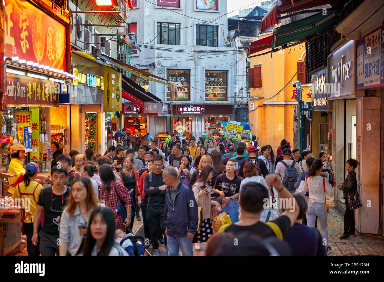 Une foule dense de touristes marchant dans une rue étroite dans le quartier historique de Macao, Chine. Banque D'Images