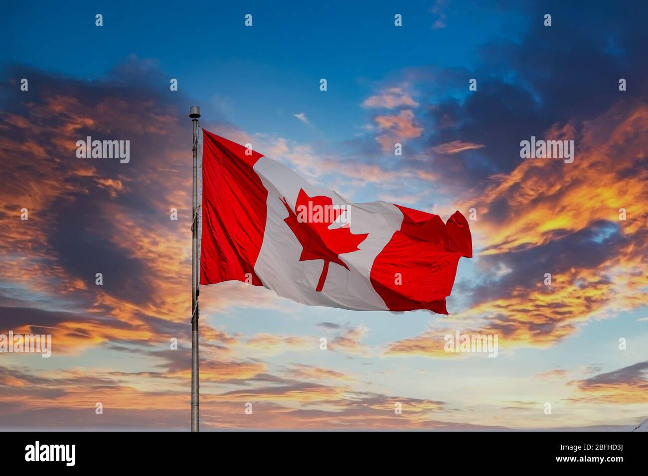 Vol avec drapeau canadien au coucher du soleil Banque D'Images