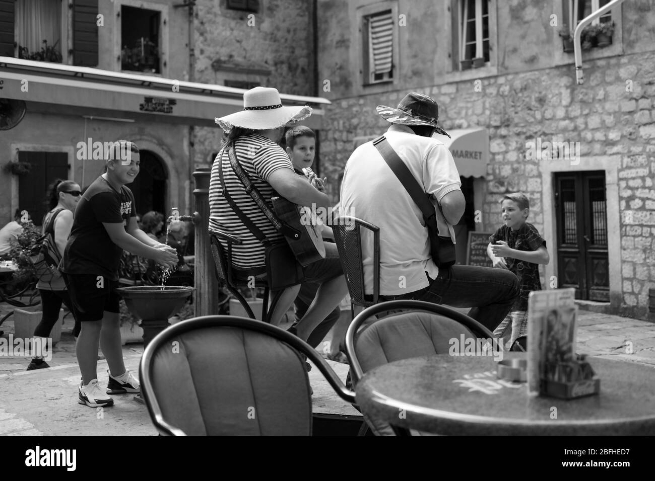 Kotor, Monténégro, 17 septembre 2019 : vue de derrière un duo guitariste et des garçons locaux dansant sur la place de la ville Banque D'Images