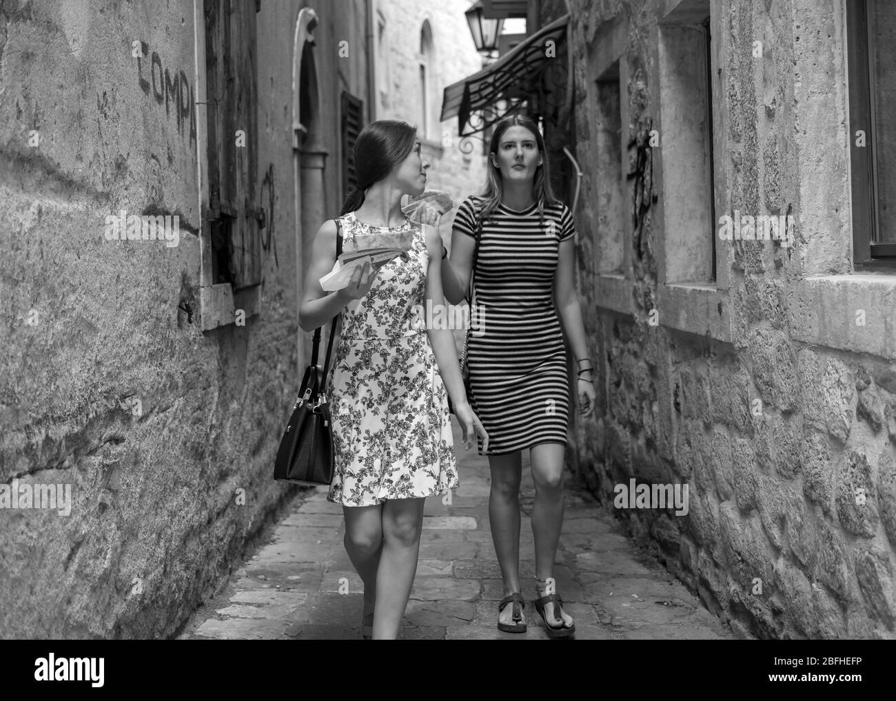 Monténégro, 17 septembre 2019 : deux jeunes femmes marchant et s'empaquent dans la rue pavée étroite de la vieille ville de Kotor Banque D'Images