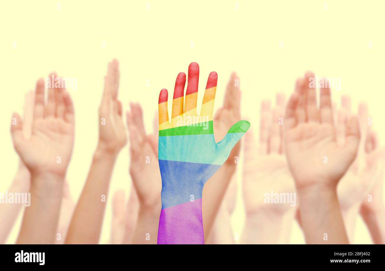 Les mains de l'homme ont peint comme le drapeau arc-en-ciel sur d'autres mains arrière-plan isolé sur blanc Banque D'Images
