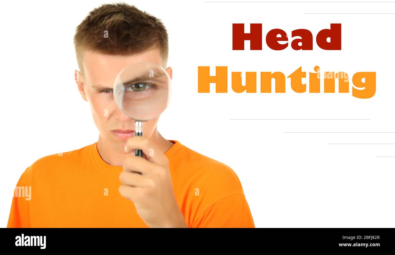 Jeune homme regardant par la loupe isolée sur blanc, concept de chasse de tête Banque D'Images