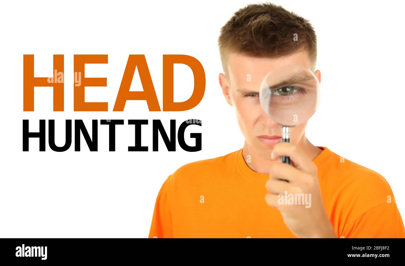 Jeune homme regardant par la loupe isolée sur blanc, concept de chasse de tête Banque D'Images