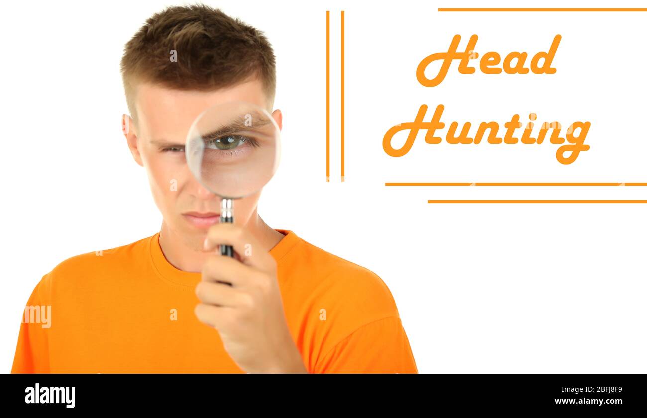 Jeune homme regardant par la loupe isolée sur blanc, concept de chasse de tête Banque D'Images