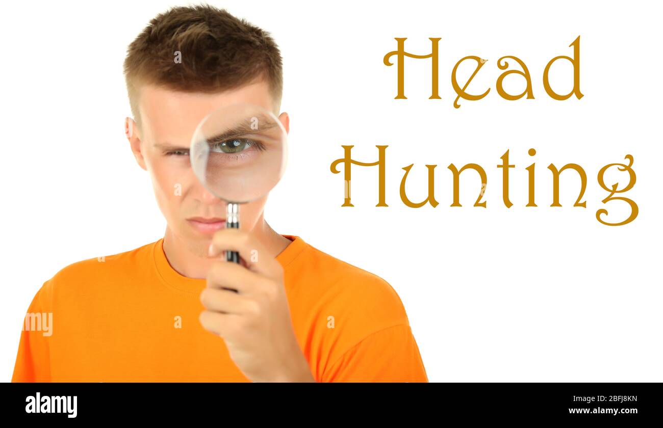 Jeune homme regardant par la loupe isolée sur blanc, concept de chasse de tête Banque D'Images