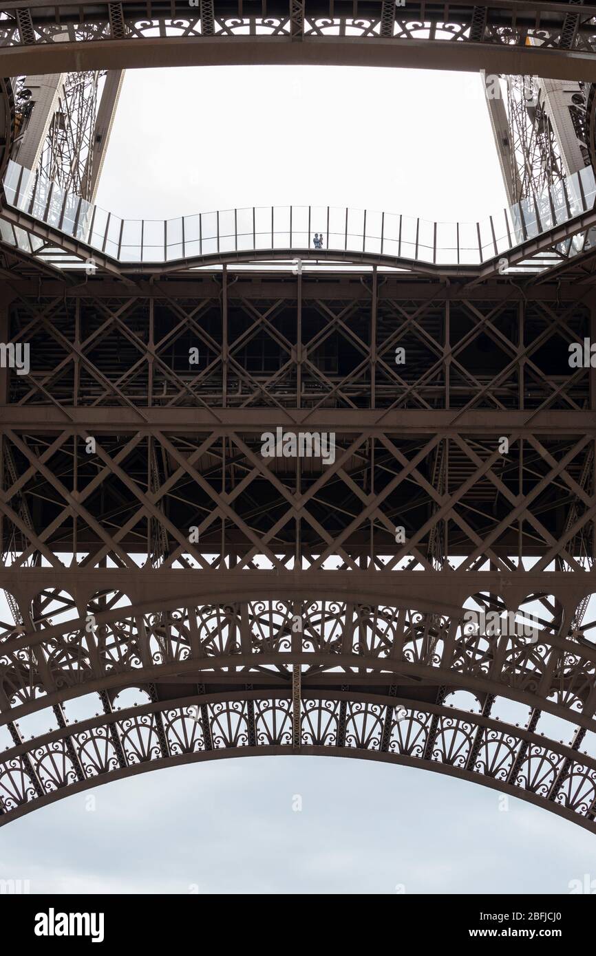 Vue à angle bas d'un père et d'un enfant debout contre la barrière au premier étage de la Tour Eiffel, Paris Banque D'Images