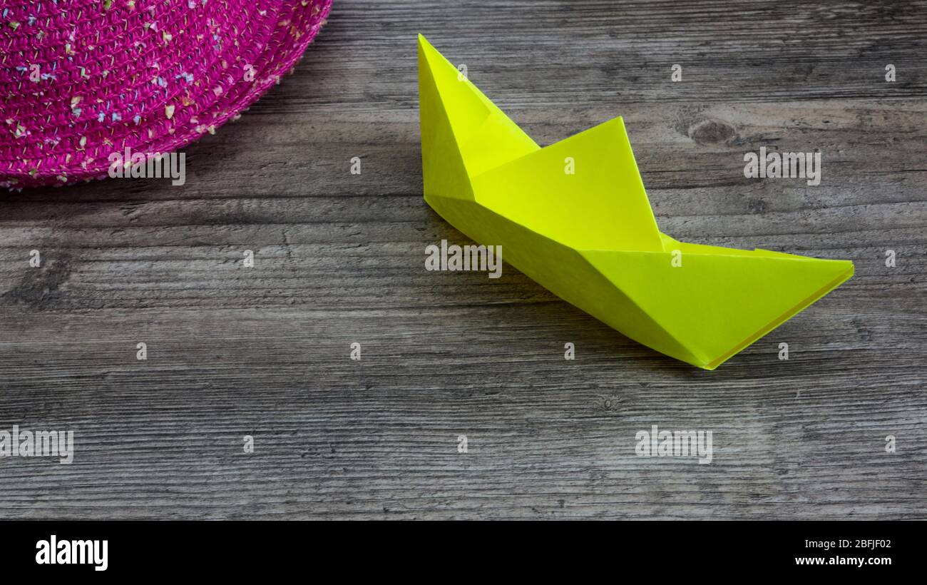 Origami, bateau jaune de papier et chapeau rose sur table en bois,  passe-temps Photo Stock - Alamy