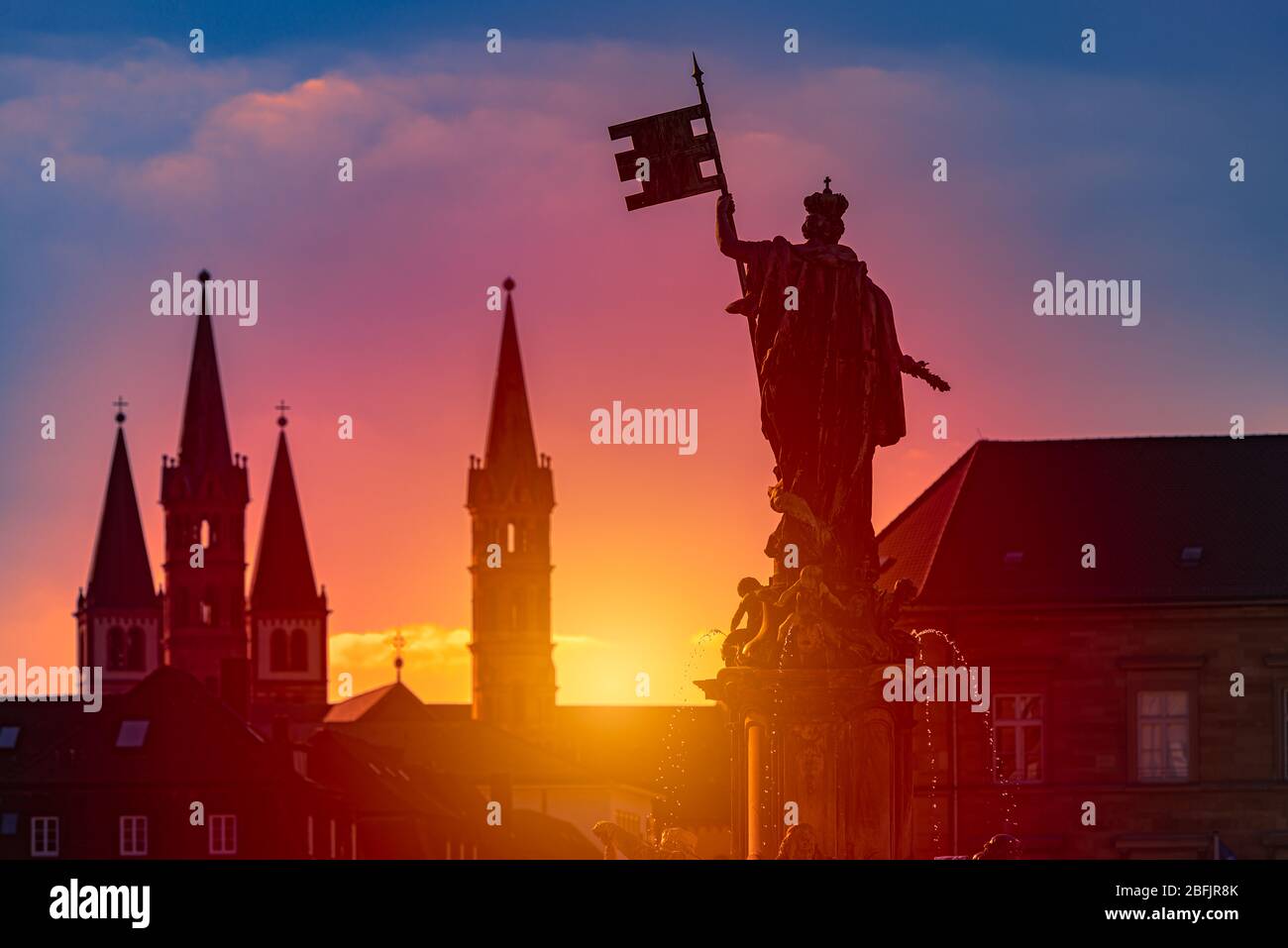 Coucher de soleil sur la ville de Wurzburg en Bavière, Allemagne. Magnifique ciel avec soleil et nuages en arrière-plan et architecture de la vieille ville en premier plan Banque D'Images