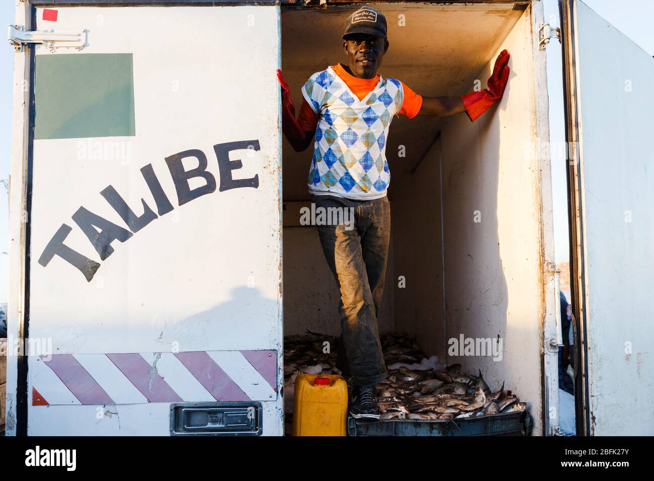 Les pêcheurs qui chargent la prise de la journée à Guet Ndar, Saint Louis, Sénégal. Banque D'Images
