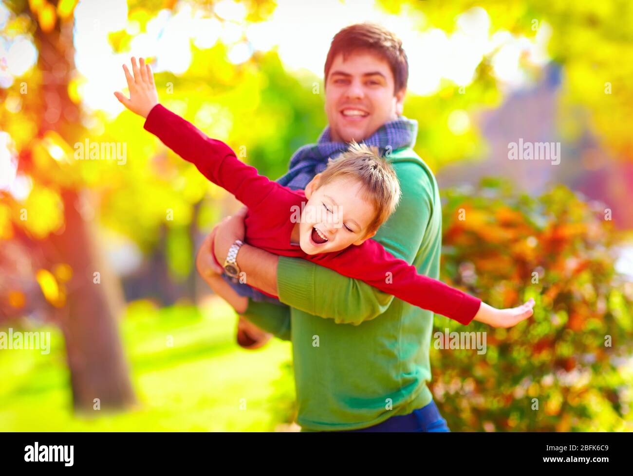 joyeux père et fils jouant ensemble dans le parc d'automne Banque D'Images
