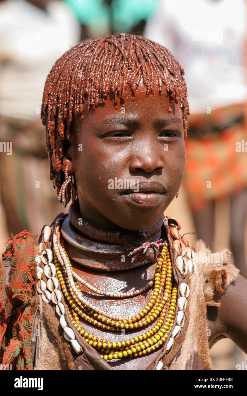 Portrait d'une jeune femme de la tribu Hamer les cheveux sont recouverts de boue ocre et de graisse animale photographiée dans la vallée de la rivière Omo, en Ethiopie Banque D'Images