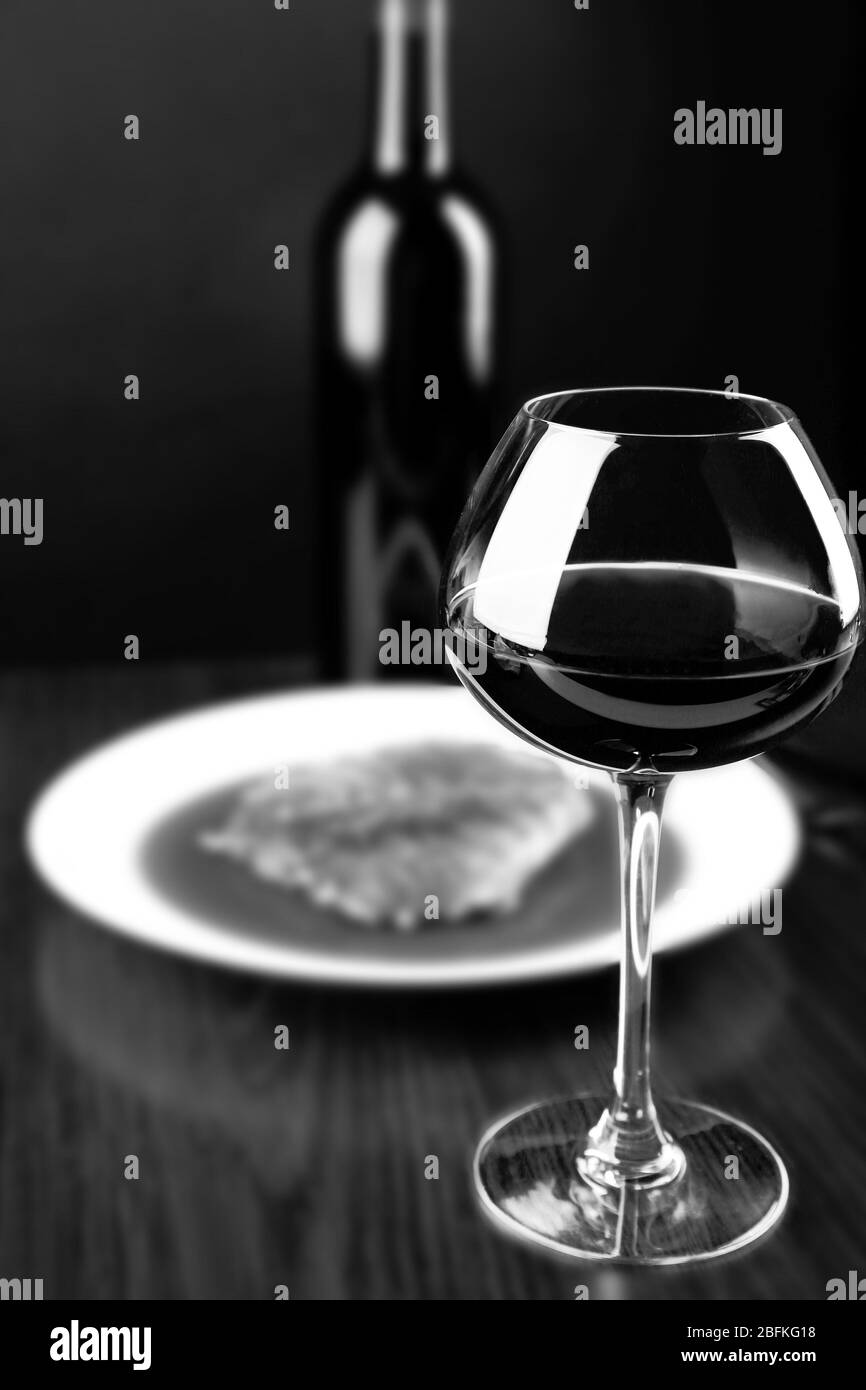 Verre de vin rouge et dîner, stylisation rétro noir et blanc Banque D'Images