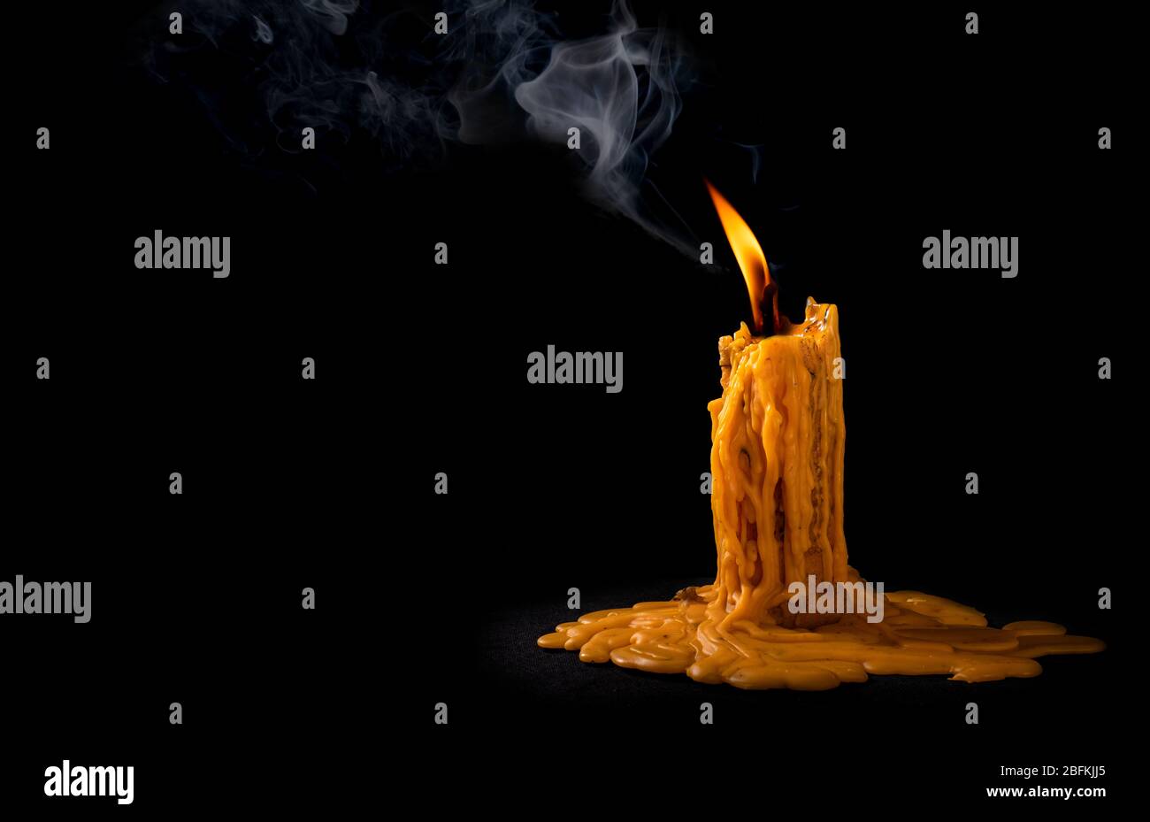 bougie flamme lumineuse brûlant de la fumée sur fond noir Banque D'Images