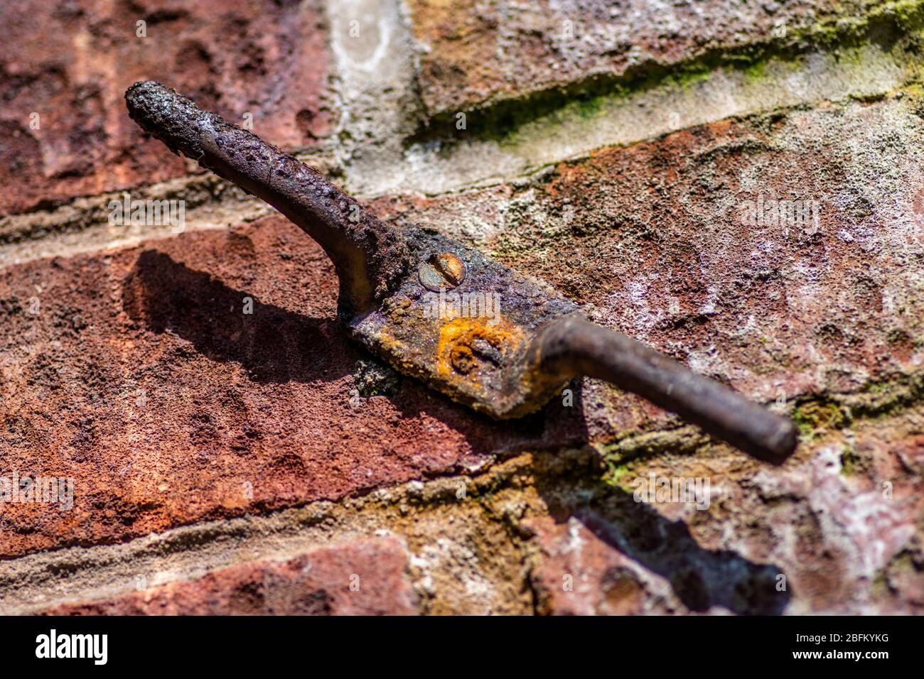 Support rouillé sur un mur de briques fixé à l'aide de vis rouillées Banque D'Images