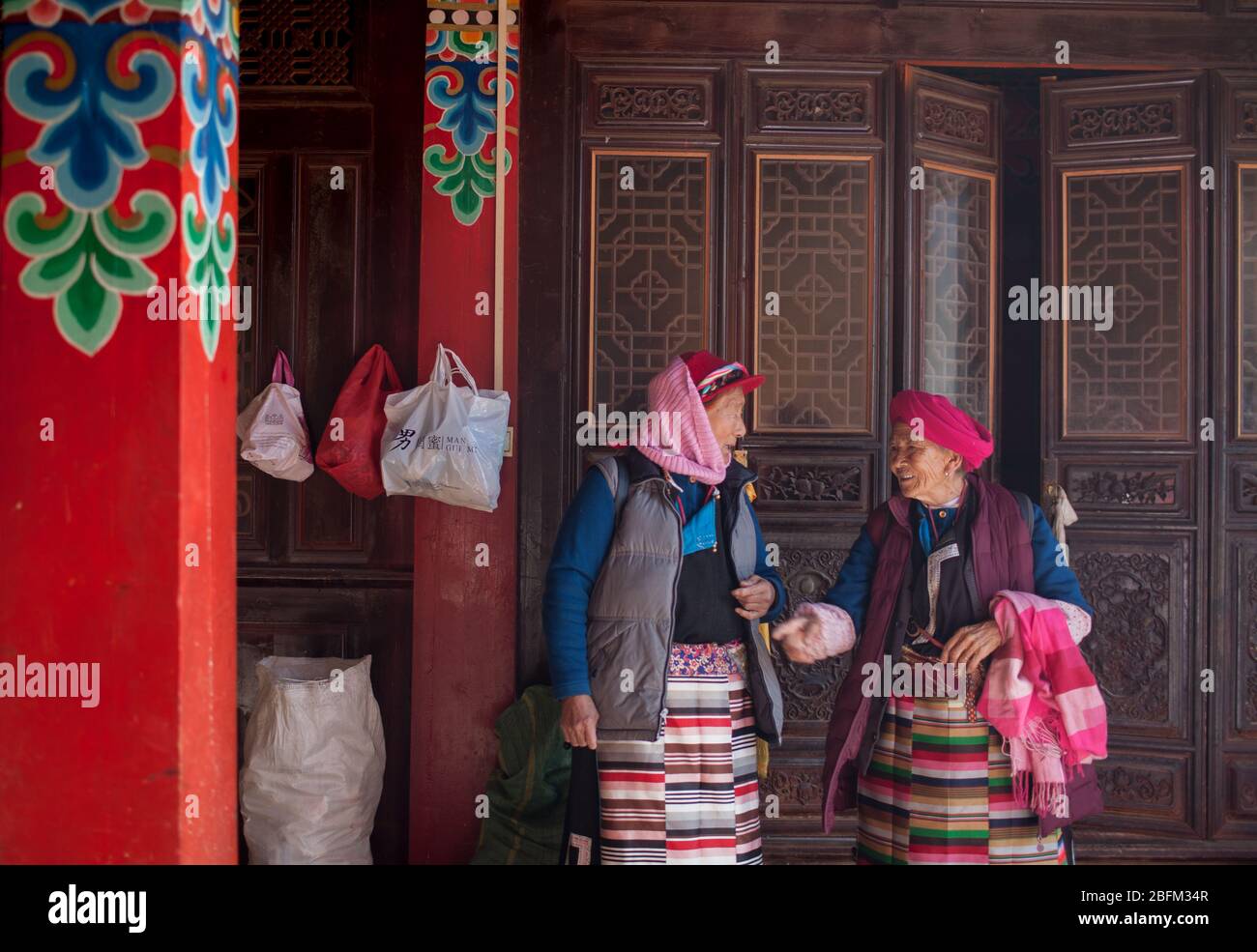 Deux femmes âgées parlant à l'intérieur du temple bouddhiste de Ringa, Shangri la, Chine 2019 Banque D'Images