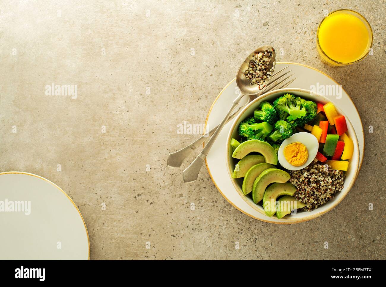 Repas de salade sain avec quinoa, oeuf, avocat et légumes frais mélangés sur fond gris vue de dessus. Alimentation et santé. Concept de repas sain Banque D'Images
