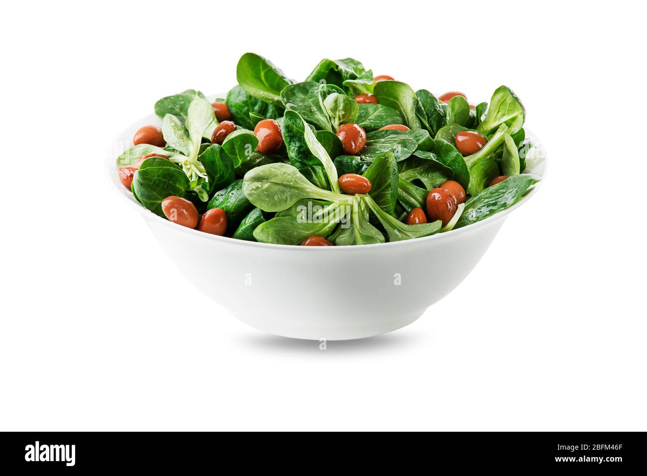 Salade de maïs vert frais feuilles ou laitue d'agneau ou Valerianella locusta avec haricots dans un bol isolé sur blanc Banque D'Images