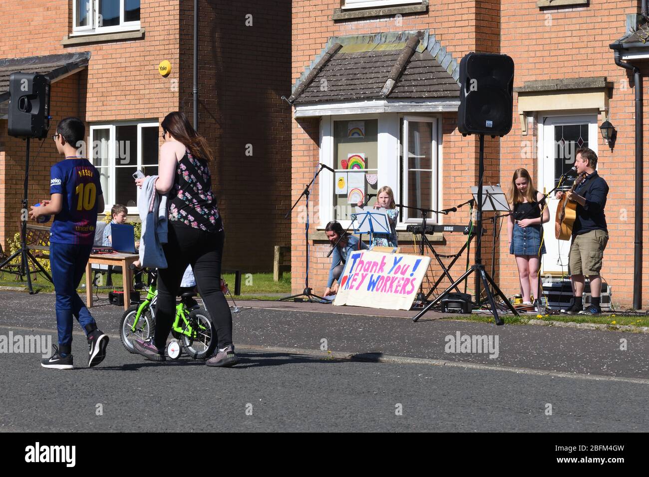 Glasgow, Écosse, Royaume-Uni. 19 avril 2020. Concert de porte une famille de Glasgow joue de la musique pour les voisins et comme un merci aux travailleurs clés de garder les esprits à la fin de la quatrième semaine de verrouillage pendant la pandémie de Coronavirus. Credit Douglas Carr/Alay Live News. Banque D'Images