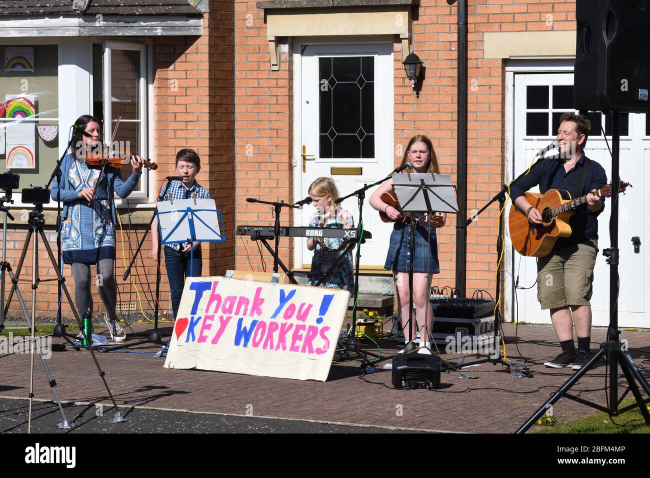 Glasgow, Écosse, Royaume-Uni. 19 avril 2020. Concert de porte une famille de Glasgow joue de la musique pour les voisins et comme un merci aux travailleurs clés de garder les esprits à la fin de la quatrième semaine de verrouillage pendant la pandémie de Coronavirus. Credit Douglas Carr/Alay Live News. Banque D'Images