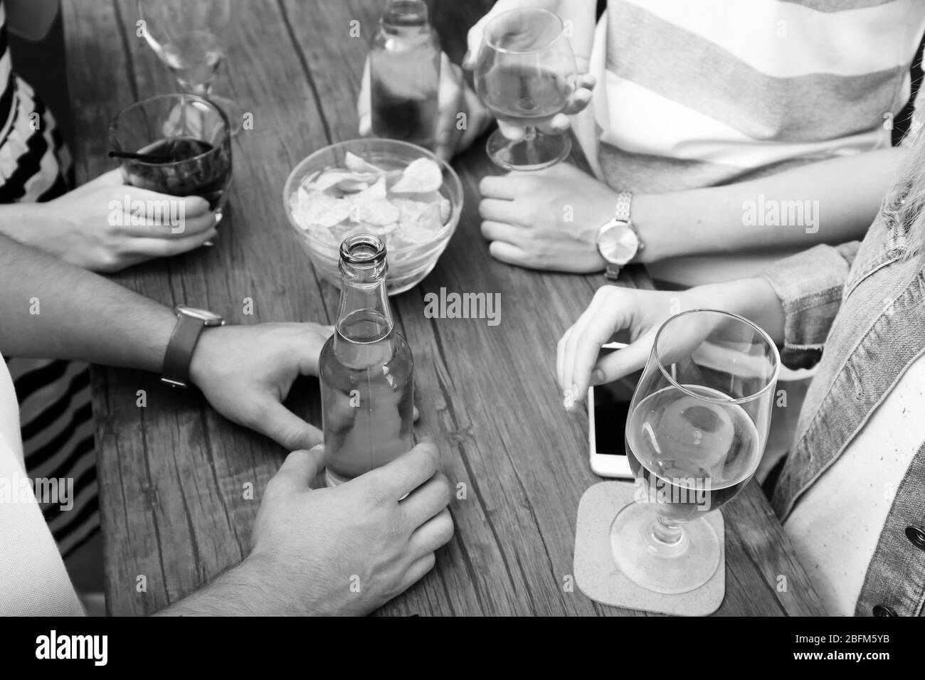 Vue sur les amis d'avoir des boissons alcoolisées au bar, close-up Banque D'Images