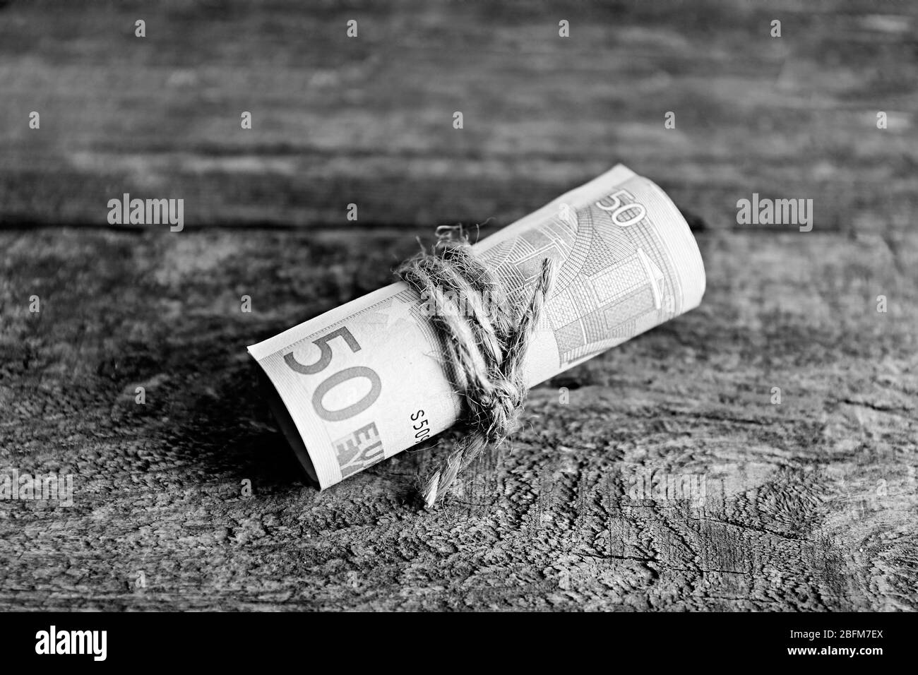 Rouleau de billets sur fond de bois Banque D'Images