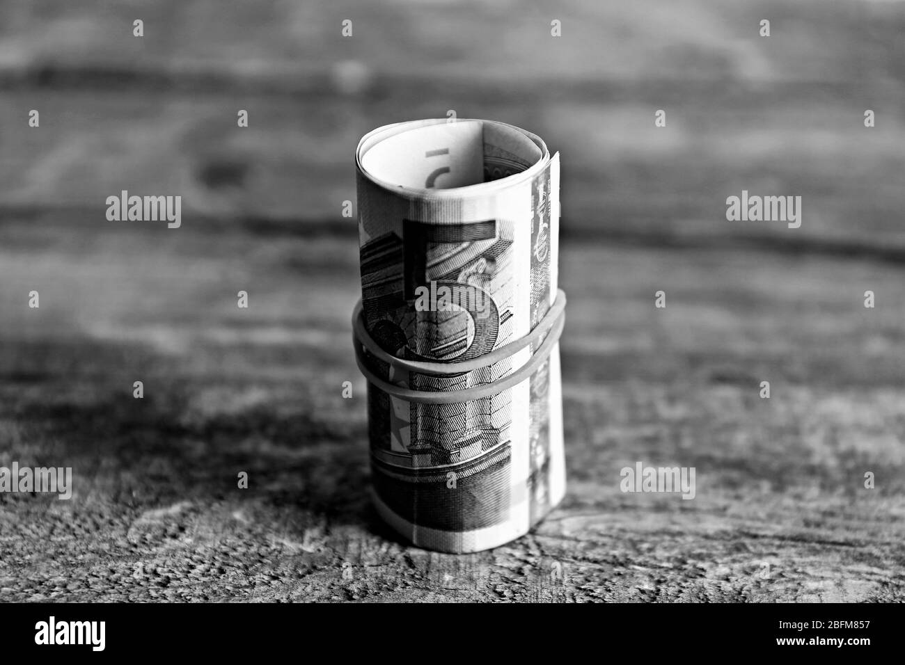 Rouleau de billets sur fond de bois Banque D'Images