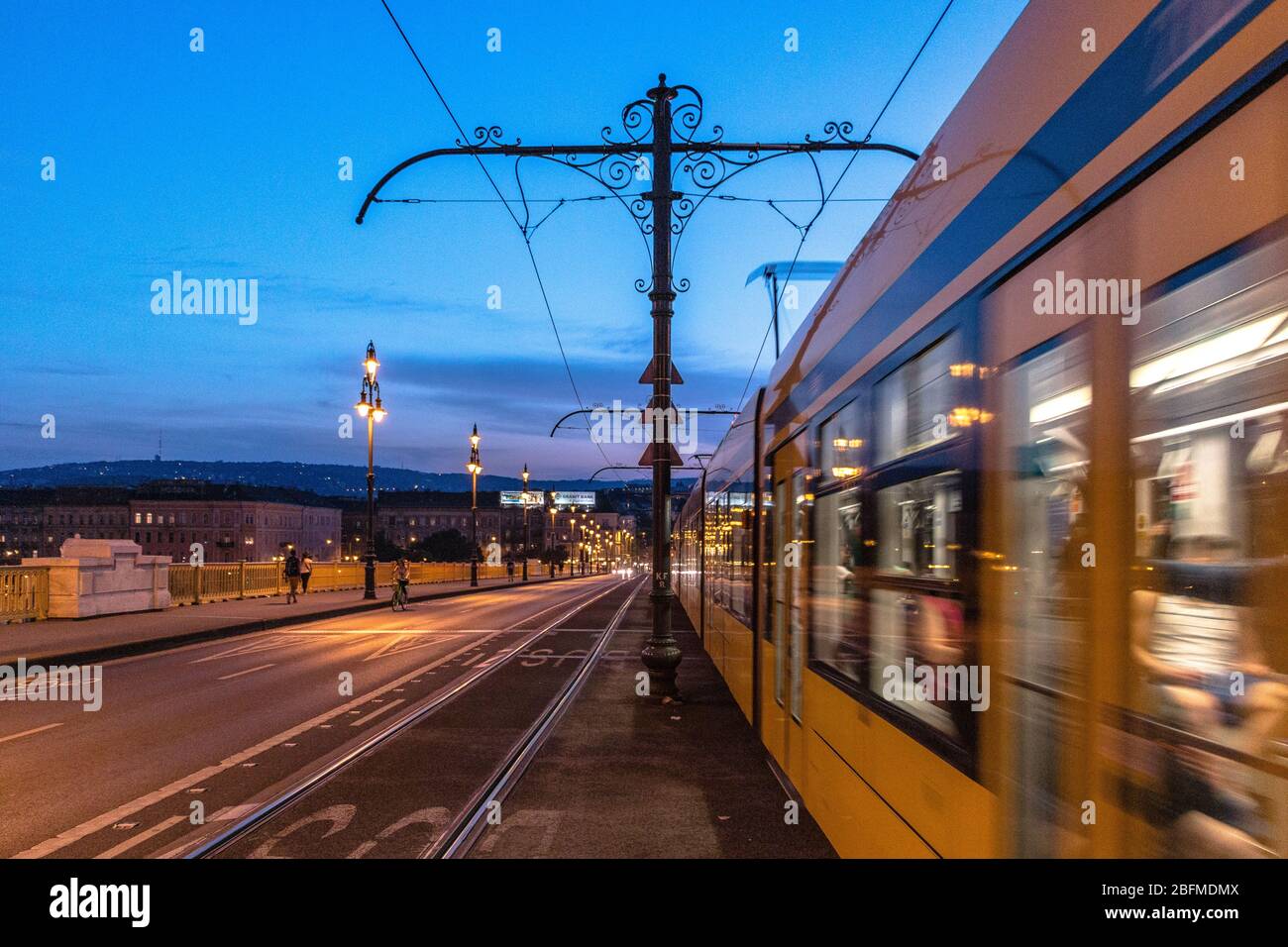 Un tramway Siemens Combino effectue un zoom sur Margaret Bridge à l'heure bleue à Budapest Banque D'Images