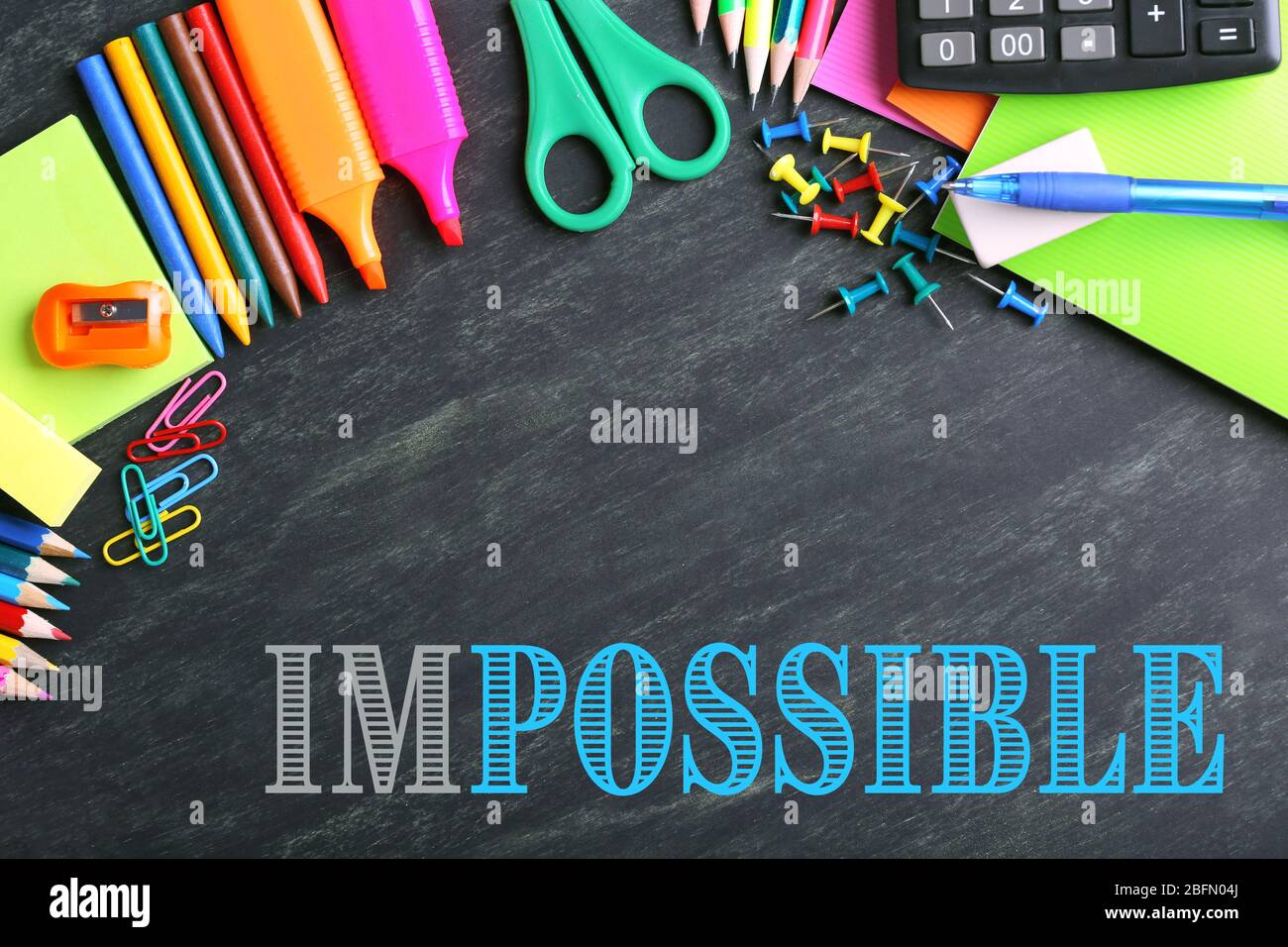 Mot impossible transformé en possible sur le tableau noir et les fournitures scolaires Banque D'Images