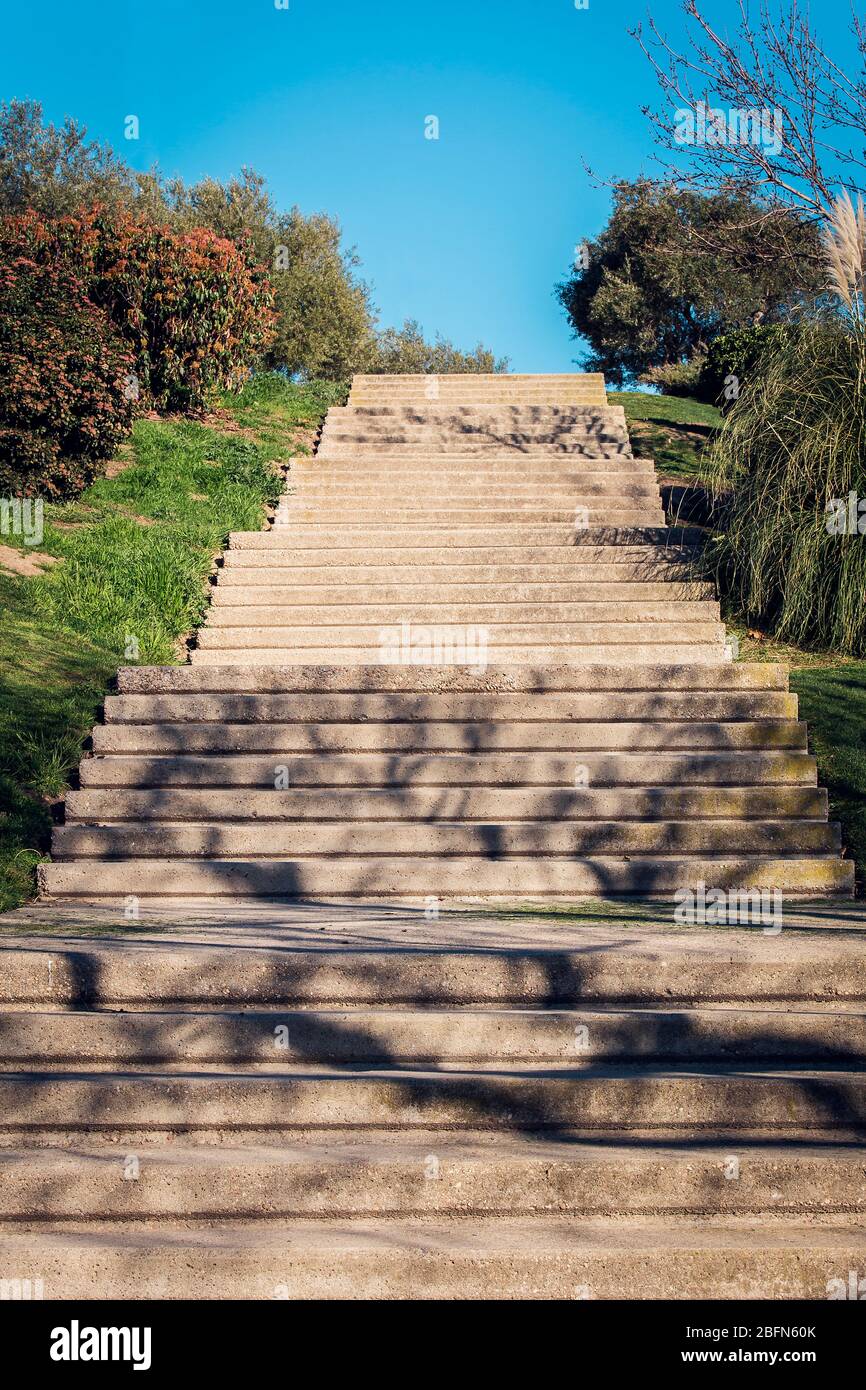 escalier vertical en pierre de granit dans un parc entouré de végétation et de ciel bleu Banque D'Images